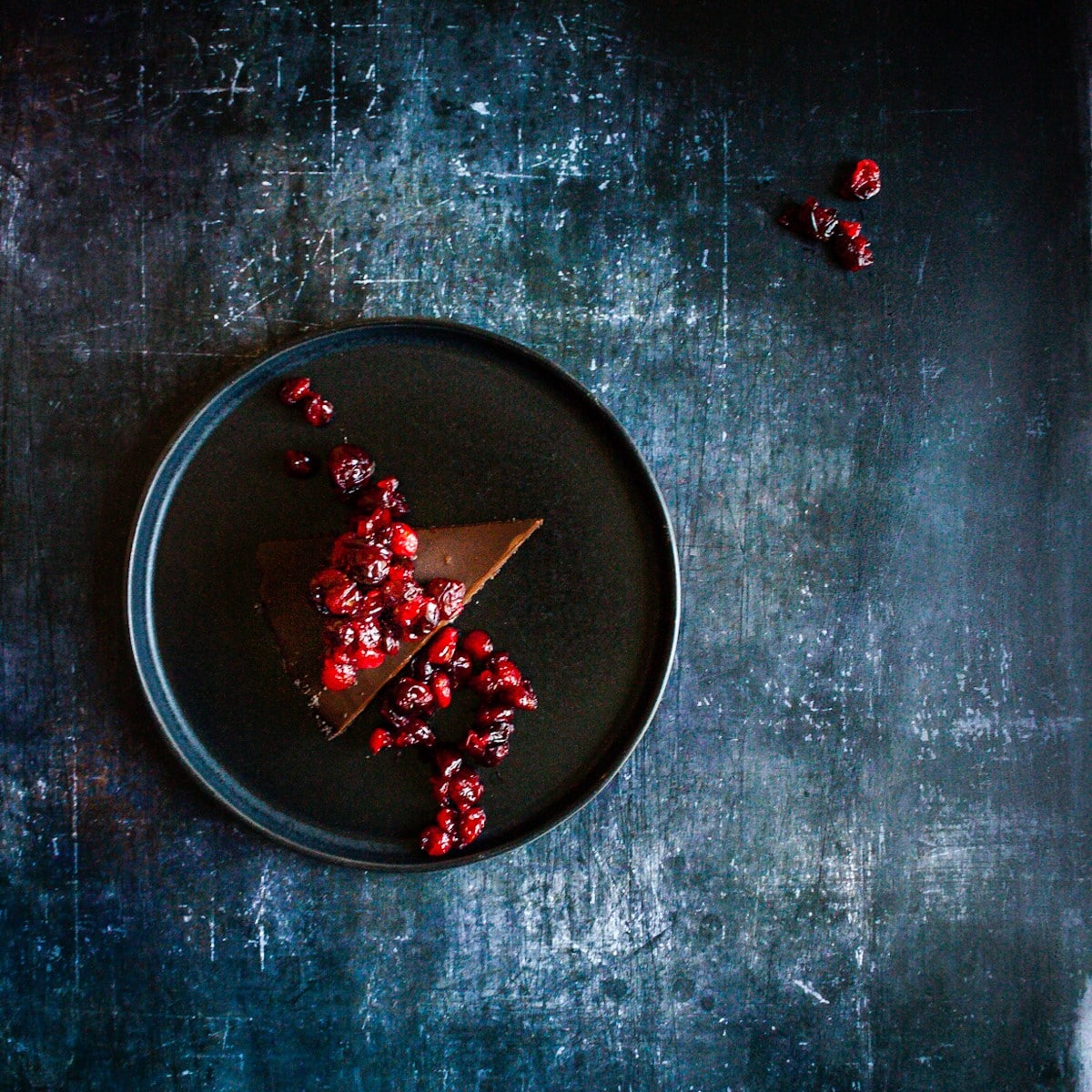 slice of chocolate tart with cranberries on a plate