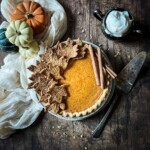 Honey pumpkin pie with pastry leaves and cinnamon sticks