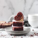 Front view of plated red velvet brownies with a cheesecake swirl.