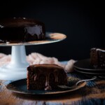 slice of chocolate brownie cake on a plate with chocolate ganache drizzle