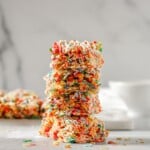 Stack of Fruity pebbles treats with bowl in the background.