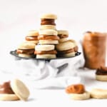 Argentine alfajores on a cake stand stacked on each other.