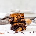 Stack of biscoff brownies with scoop of cookie butter in background.